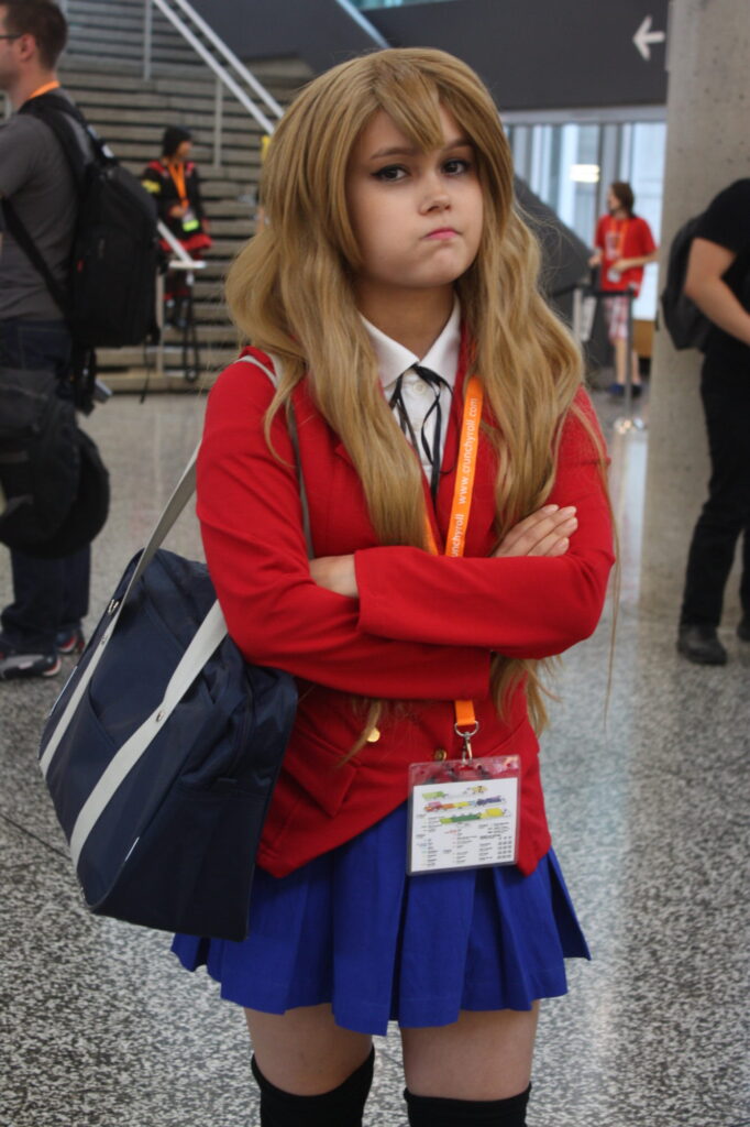 Cosplayer caracterizada como Taiga Aisaka (Toradora!), com expressão séria e postura defensiva.